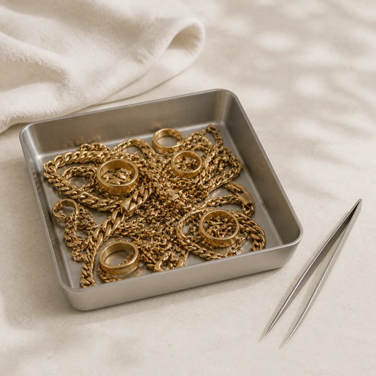 Commercial scrap-gold chains and rings arranged in an assay tray